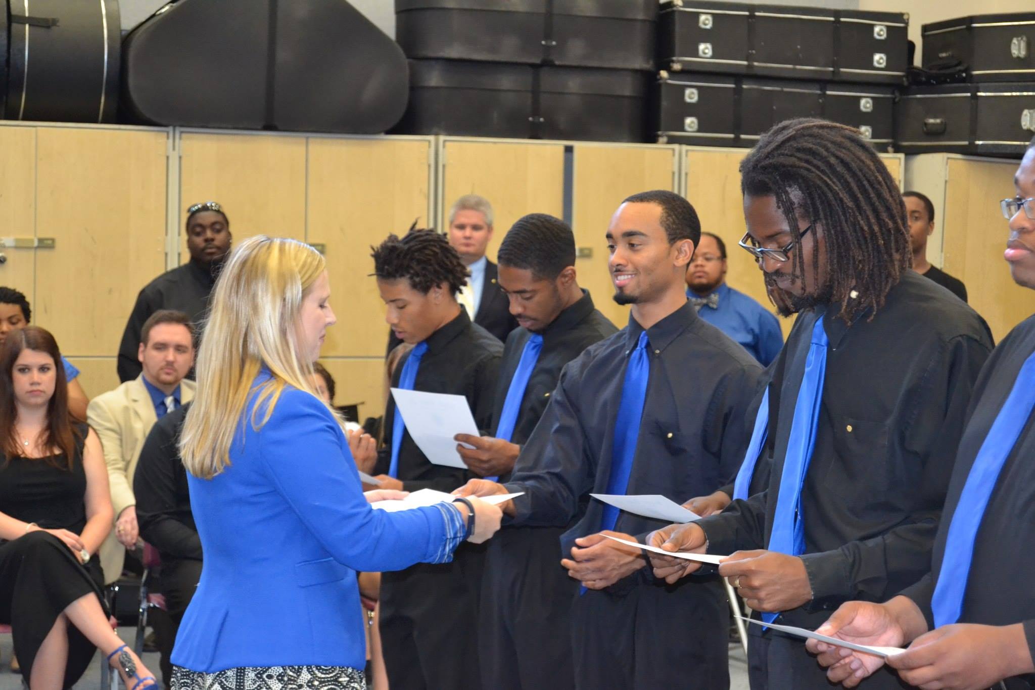 Tammi Ramsey handing Nu Iota's first President, Demetrius Deloatch, his membership 
                    shingle with the other Brothers from the Nu Iota Chapter at Elizabeth City State University after their installation 
                    in 2014